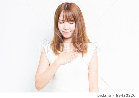 胸に手を当てる若い女性 69420526
