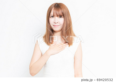 胸に手を当てる若い女性 69420532