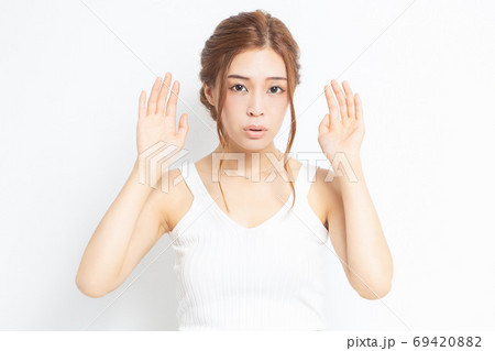 耳を澄ます若い女性 69420882