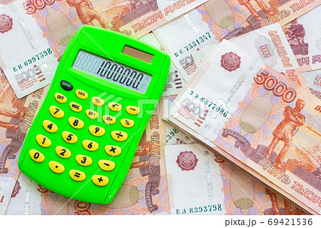 Against the background of money is a bundle of five-thousandth bills and a calculator with the number one million Against the background of money is a bundle of five-thousandth bills and a calculator with the number one million 69421536