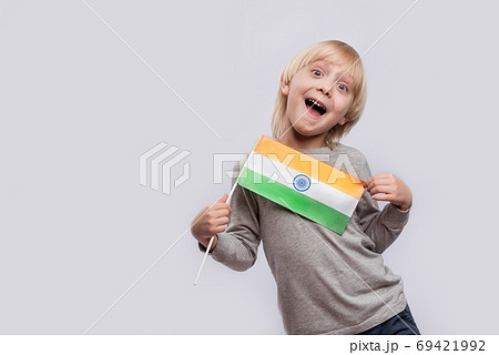 Happy boy holding flag of India and makes funny faces. Learning hindi 69421992