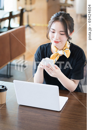 カフェでノートパソコンを開く若い女性の写真素材