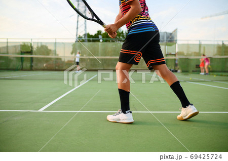 Athletic tennis players, training on outdoor court Athletic tennis players, training on outdoor court 69425724