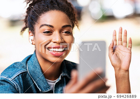 African Girl Making Video Call Using Phone Waving Hello Outdoors African Girl Making Video Call Using Phone Waving Hello Outdoors 69426889