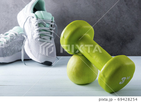 1 green dumbbell,  Apple, gray sneakers on a gray 69428254