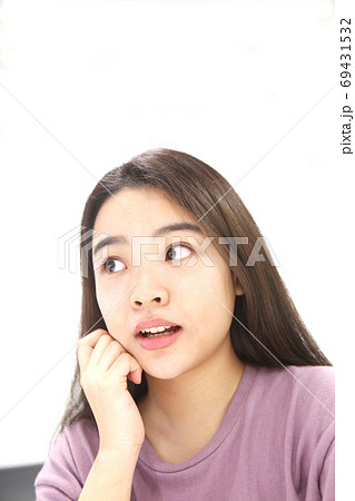 頬杖をつく上目線の若い女性 頬杖をつく上目線の若い女性 69431532