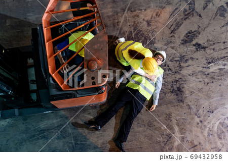 Warehouse worker do CPR after accident top view Warehouse worker do CPR after accident top view 69432958