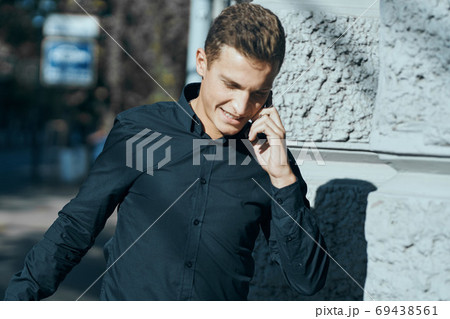 Business man in a shirt near the building with documents in his hands Business man in a shirt near the building with documents in his hands 69438561