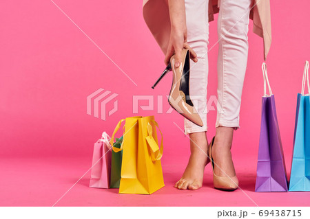 shopping bags female feet in shoes Shopaholic pink background shopping bags female feet in shoes Shopaholic pink background 69438715