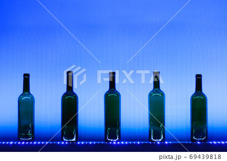 abstract empty wine bottles with blue led illumination 69439818
