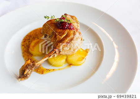 roasted duck leg with potato and orange sauce 69439821