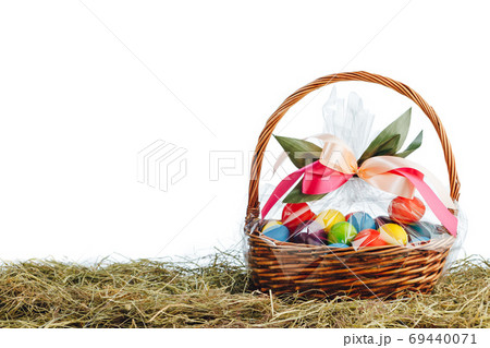 Easter gift basket with multicolor eggs, white background 69440071
