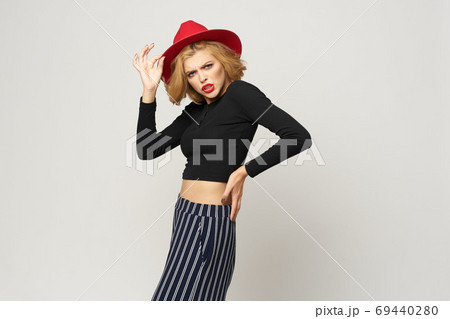 Fashionable woman in red hat black blouse red lips cropped view light background emotions Fashionable woman in red hat black blouse red lips cropped view light background emotions 69440280
