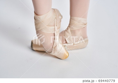 Ballerina in a white tutu dance performed on a light background Ballerina in a white tutu dance performed on a light background 69440779