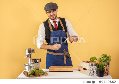 Midsection of male chef sharpening knife in commercial kitchen 69440882