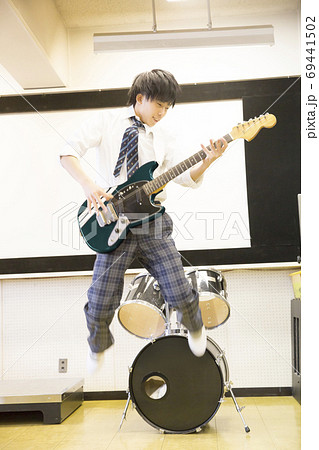 ギターを弾く高校生の写真素材