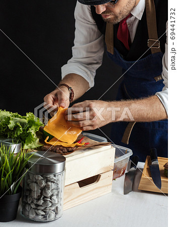 Male Chef prepares yummy fresh burger, close up 69441732