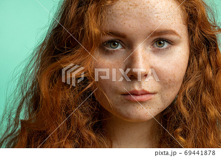 Close-up of beautiful red-haired freckled girl with loose curly hair 69441878