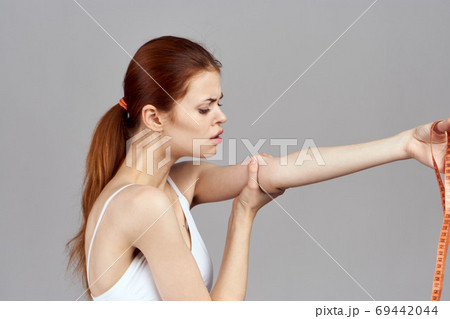 Woman with measuring tape in white t-shirt health light background 69442044