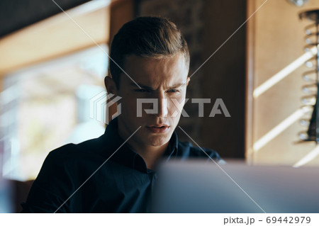 Business man freelancer with laptop in cafe at the table manager documents cup of coffee model Business man freelancer with laptop in cafe at the table manager documents cup of coffee model 69442979