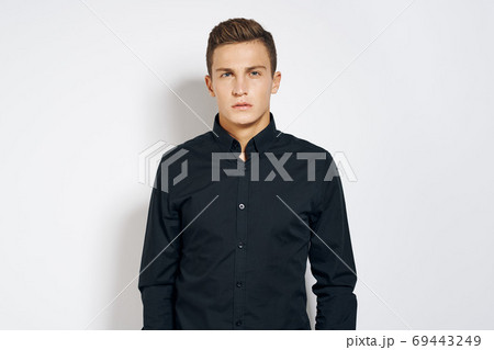 Man in black shirt lifestyle emotions modern style cropped view light background 69443249
