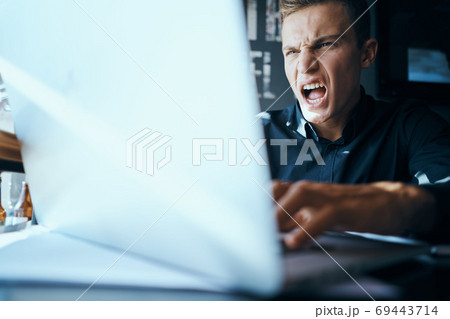Business man freelancer with laptop in cafe at the table manager documents cup of coffee model Business man freelancer with laptop in cafe at the table manager documents cup of coffee model 69443714