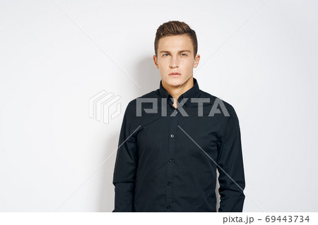 Man in black shirt lifestyle emotions modern style cropped view light background 69443734
