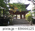 緑と紅葉の後ろにある階段の上の山門 69444125