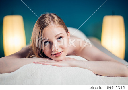 Young, beautiful woman in spa salon lying on massage table waiting for massage. 69445316