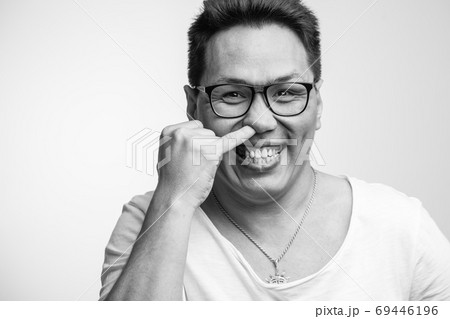 Happy funny Asian man in his 30s in white usual t-shirt with different positive emotions Happy funny Asian man in his 30s in white usual t-shirt with different positive emotions 69446196