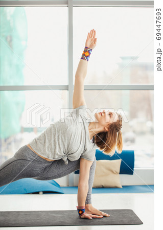 woman practicing yoga , Triangle pose in fitness center woman practicing yoga , Triangle pose in fitness center 69447693