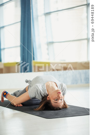 Attractive young woman lying in Shavasanaor Dead Body Posture. 69448189