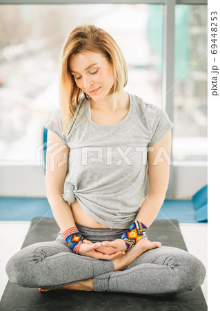 Sporty attractive woman sitting in Lotus pose Sporty attractive woman sitting in Lotus pose 69448253