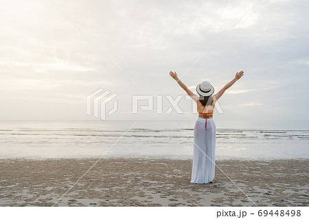 freedom woman in bikini walking with arms raised on sea beach 69448498