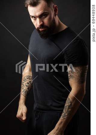Confidence and strength. Adult athletic man standing over black background 69448938