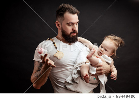 Father holding and taking care of little infant baby, feeding from bottle. Father holding and taking care of little infant baby, feeding from bottle. 69449480