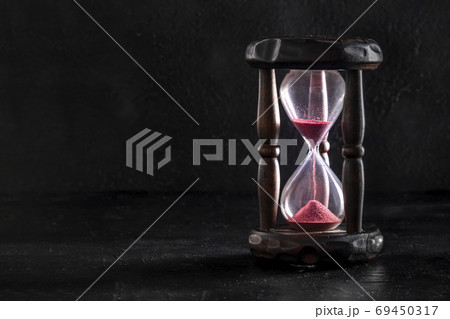 Time concept. An hourglass on a black background Time concept. An hourglass on a black background 69450317