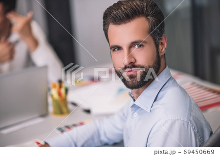 Bearded male sitting at table, looking into camera Bearded male sitting at table, looking into camera 69450669