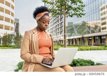 Young elegant businesswoman of African ethnicity with laptop on her knees 69450670