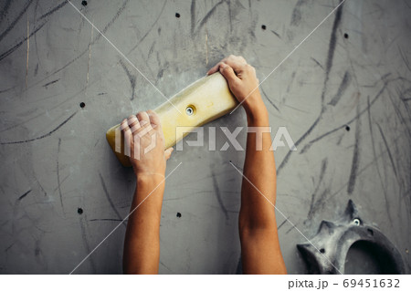 Climber hands holding artificial boulder in climbing gym, closeup shot Climber hands holding artificial boulder in climbing gym, closeup shot 69451632