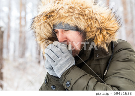 Man drink a hot drink from a thermos and enjoy winter nature. Man drink a hot drink from a thermos and enjoy winter nature. 69451638