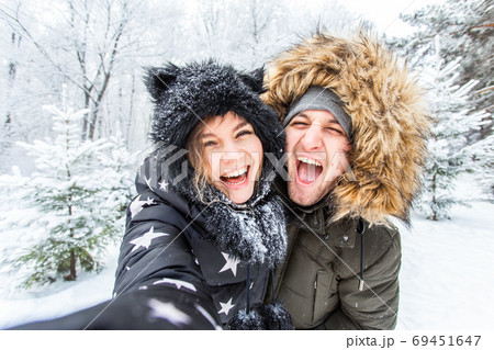 Season, love, technology and leisure concept - happy couple taking selfie by smartphone over winter background 69451647