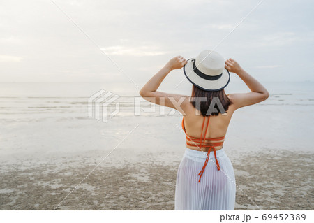 cheerful woman in bikini standing at sea beach cheerful woman in bikini standing at sea beach 69452389