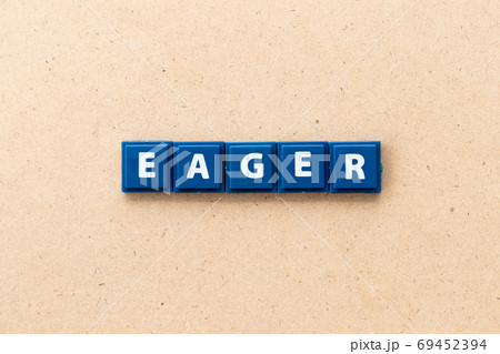 Tile letter in word eager on wood background Tile letter in word eager on wood background 69452394