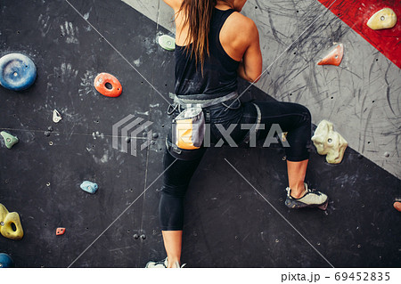 Beautiful young woman taking a big step up an artificial wall 69452835