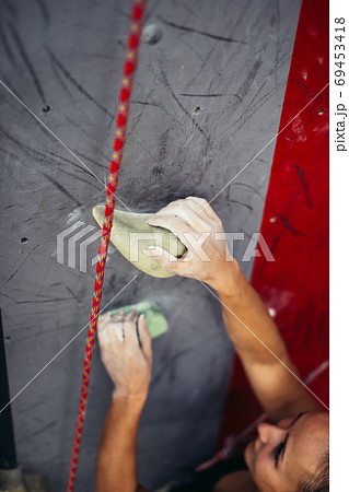 Female climber hands holding artificial boulder in climbing gym, closeup shot Female climber hands holding artificial boulder in climbing gym, closeup shot 69453418