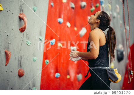 Side view of athletic woman climbing indoors 69453570