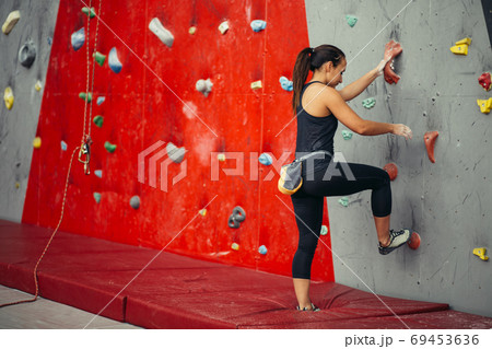 Rear view of sportswoman looking at climbing wall 69453636