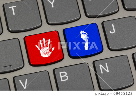 Printout of hand and foot on computer keys 69455122