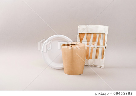 eco friendly disposable dishes made of bamboo wood and paper on Gray background. Draped spoons, fork eco friendly disposable dishes made of bamboo wood and paper on Gray background. Draped spoons, fork 69455393